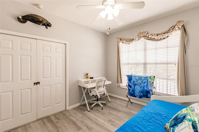 bedroom with ceiling fan, light wood-type flooring, and a closet