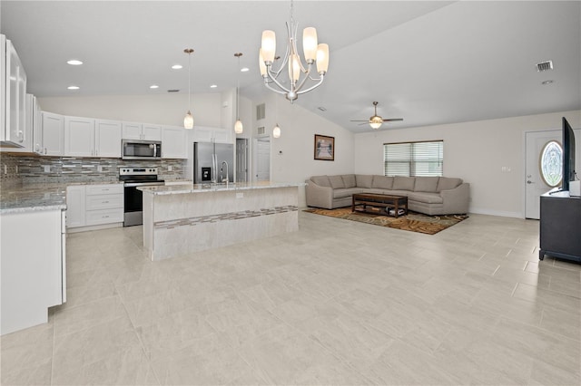 kitchen featuring white cabinets, lofted ceiling, hanging light fixtures, appliances with stainless steel finishes, and ceiling fan with notable chandelier