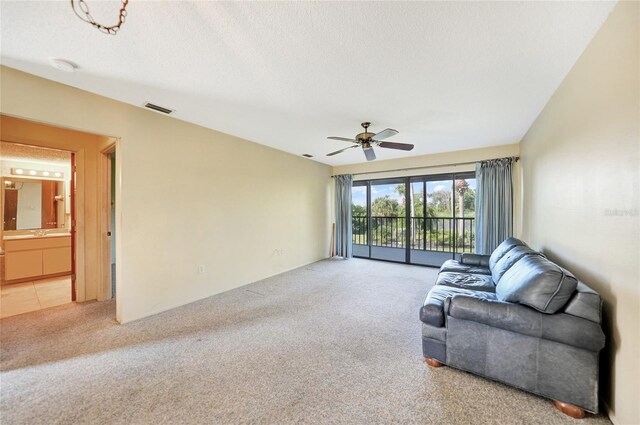 unfurnished living room featuring ceiling fan, a textured ceiling, and carpet flooring