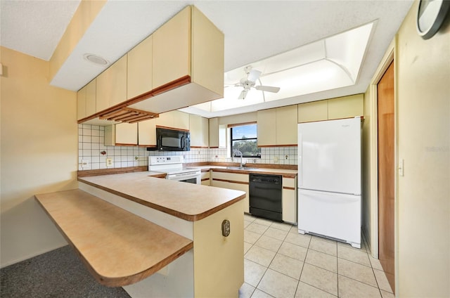 kitchen with ceiling fan, kitchen peninsula, cream cabinets, black appliances, and decorative backsplash