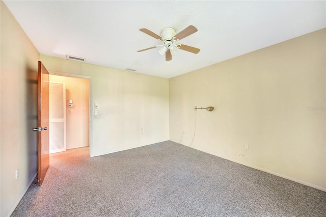 carpeted spare room featuring ceiling fan