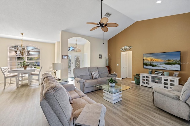 living room with ceiling fan, french doors, high vaulted ceiling, and light hardwood / wood-style flooring