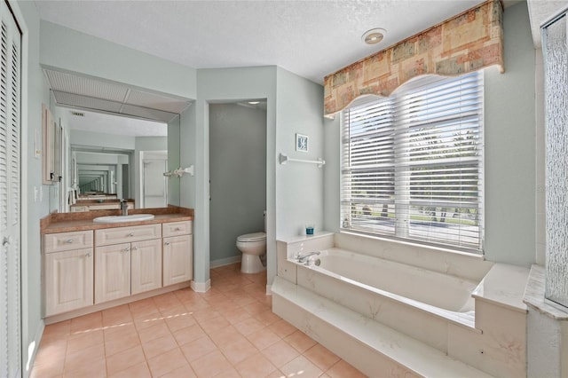 bathroom featuring toilet, vanity, tile patterned floors, and a bathing tub