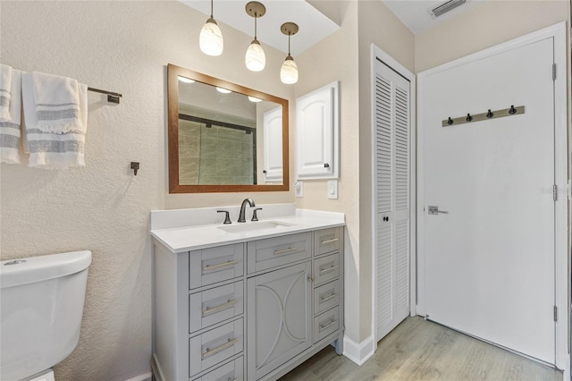 bathroom with wood-type flooring, vanity, and toilet