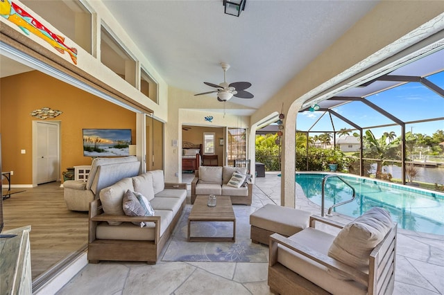 view of patio with an outdoor living space, a water view, glass enclosure, and ceiling fan