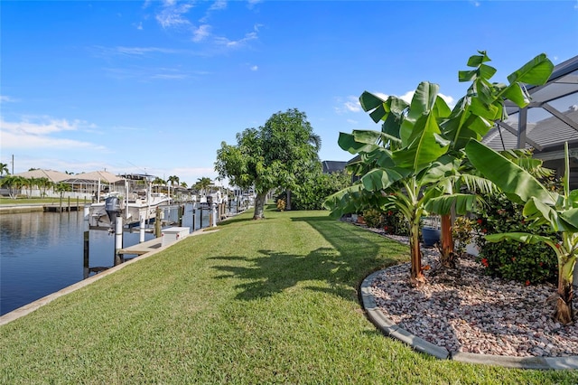 dock area with a water view, glass enclosure, and a lawn