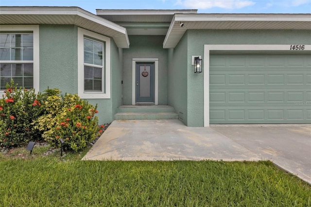 entrance to property with a garage and a yard