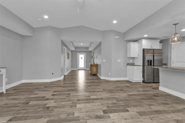 unfurnished living room featuring light wood-type flooring and vaulted ceiling