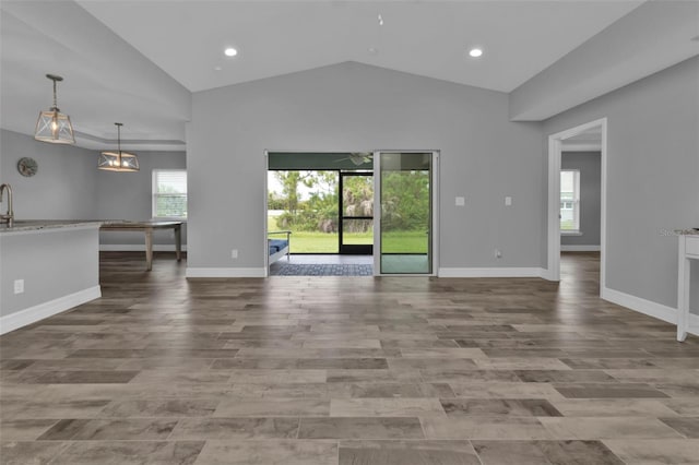 unfurnished living room with lofted ceiling and plenty of natural light