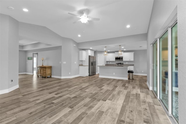 unfurnished living room featuring ceiling fan and light hardwood / wood-style flooring