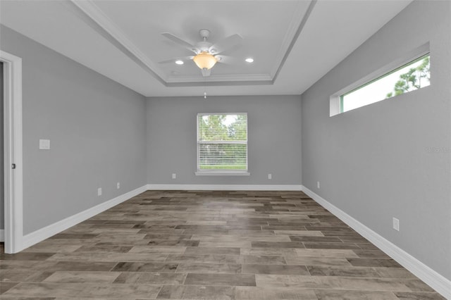 unfurnished room with ornamental molding, a tray ceiling, hardwood / wood-style floors, and ceiling fan