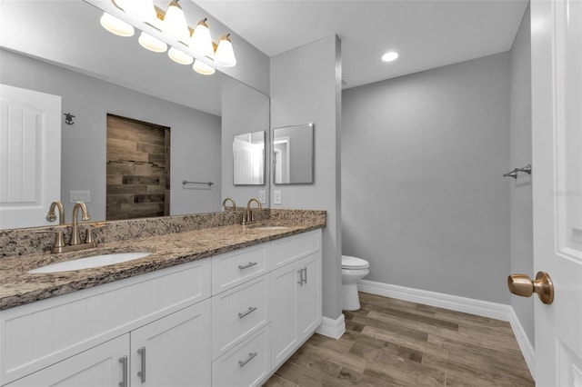 bathroom with hardwood / wood-style flooring, vanity, and toilet