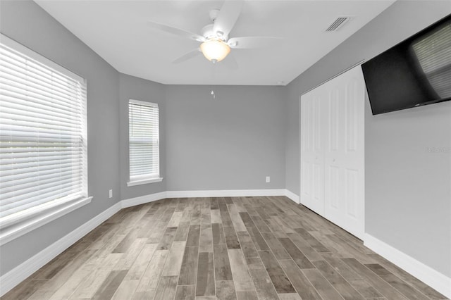 spare room with light wood-type flooring and ceiling fan