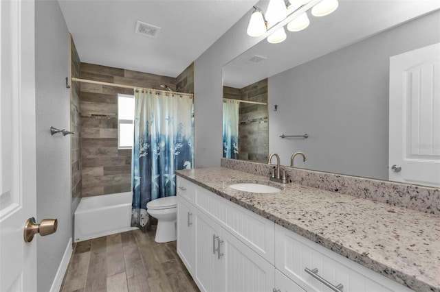 full bathroom with wood-type flooring, vanity, shower / tub combo, and toilet