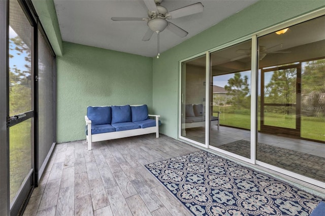 unfurnished sunroom with ceiling fan