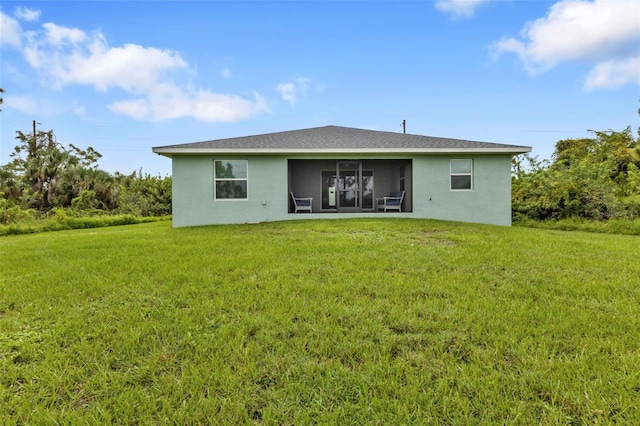 rear view of property with a sunroom and a lawn