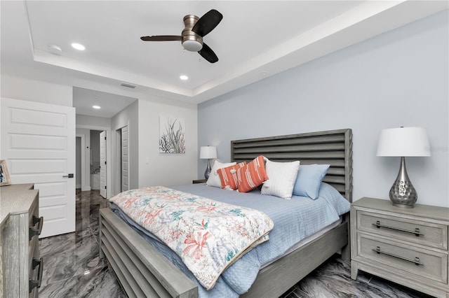 bedroom with ceiling fan and a raised ceiling