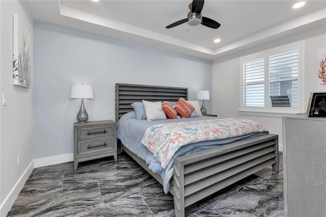 bedroom featuring a raised ceiling and ceiling fan