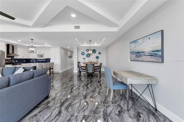 interior space with a tray ceiling and sink