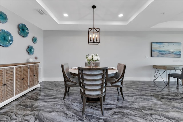 dining room featuring a raised ceiling and a chandelier