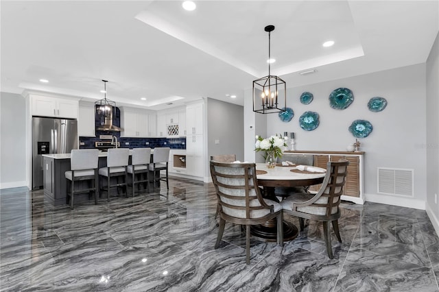 dining room featuring an inviting chandelier and a tray ceiling