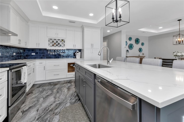 kitchen featuring appliances with stainless steel finishes, white cabinetry, and a notable chandelier