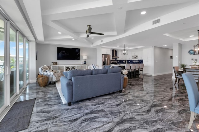 living room with ceiling fan with notable chandelier