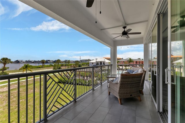 balcony with ceiling fan and a water view