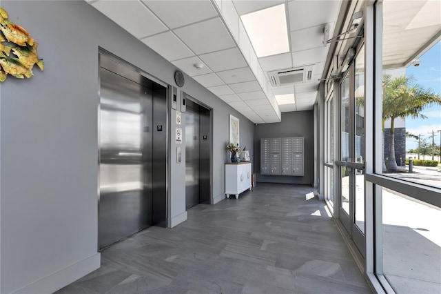 hall featuring a paneled ceiling and elevator