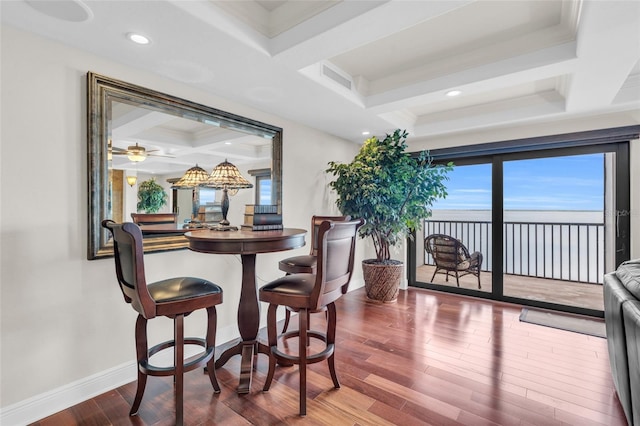 dining space with ornamental molding, beam ceiling, coffered ceiling, and hardwood / wood-style flooring