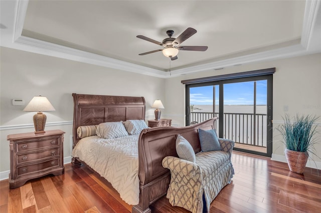 bedroom with wood-type flooring, ceiling fan, a raised ceiling, and access to outside