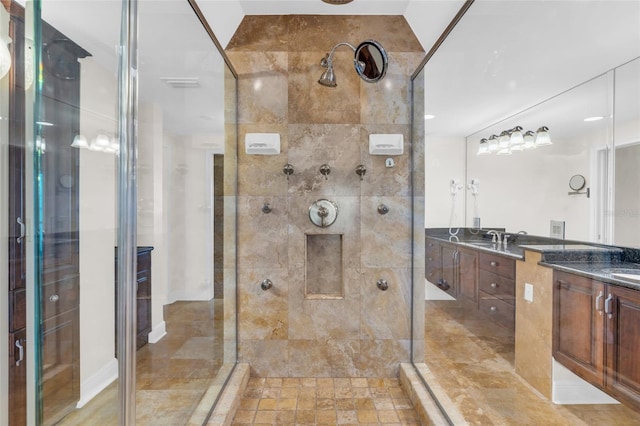 bathroom with a tile shower, lofted ceiling, and vanity