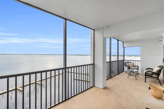 sunroom featuring a water view