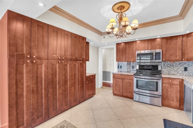 kitchen with decorative light fixtures, appliances with stainless steel finishes, a notable chandelier, crown molding, and decorative backsplash