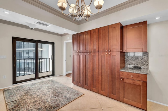 kitchen featuring tasteful backsplash, a notable chandelier, light tile patterned floors, crown molding, and light stone countertops