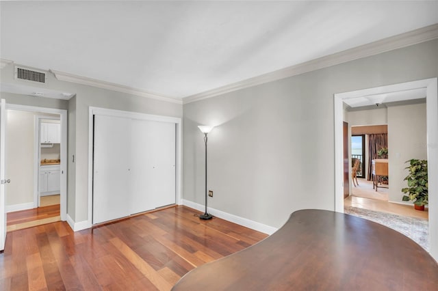 unfurnished office featuring wood-type flooring and ornamental molding