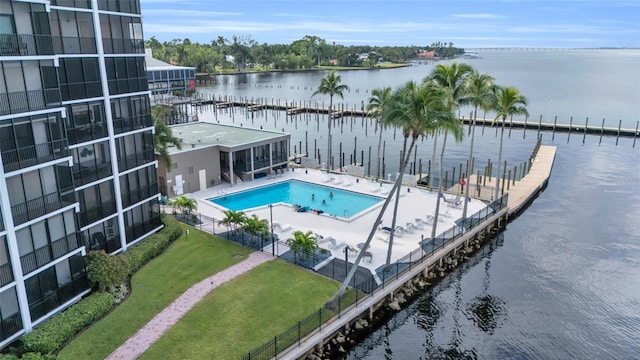 view of pool with a water view, a patio area, and a yard