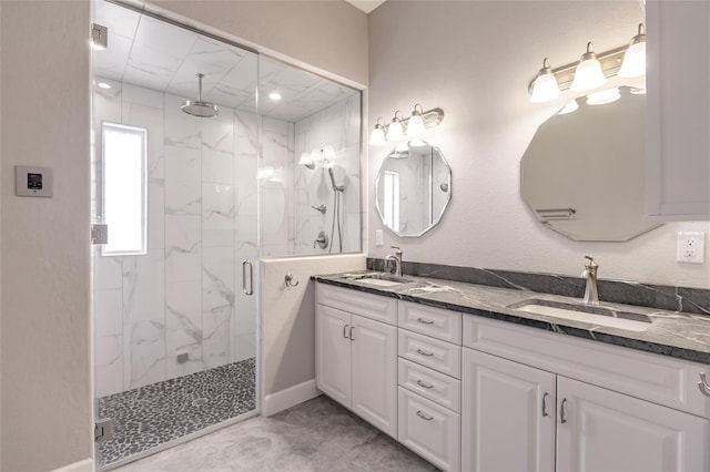 bathroom featuring a shower with door and vanity