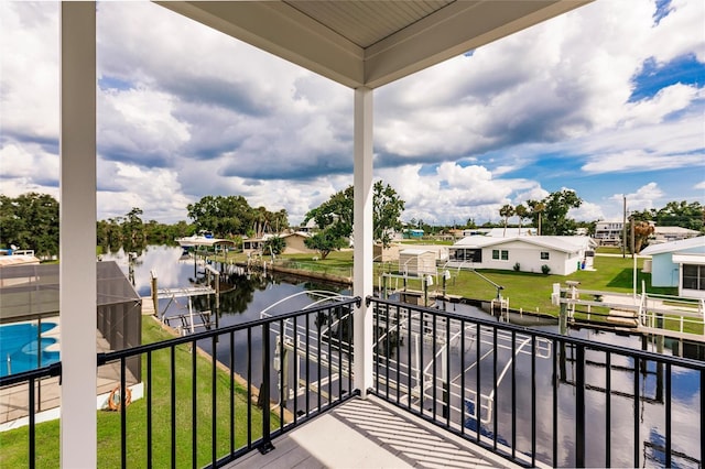balcony with a residential view, a water view, and a dock