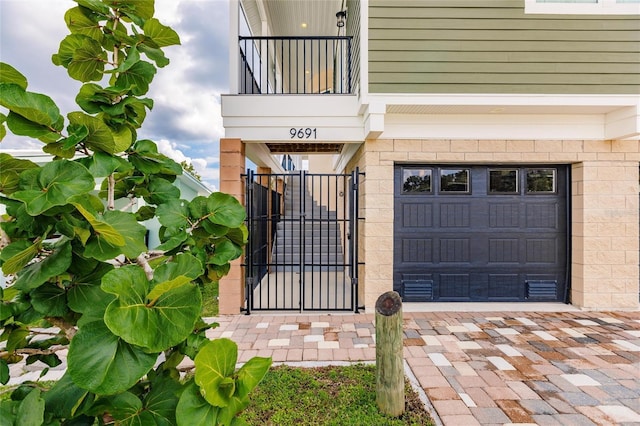 doorway to property featuring a gate, driveway, and a garage