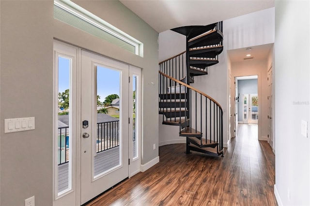 entryway with plenty of natural light, dark wood-type flooring, baseboards, and stairs