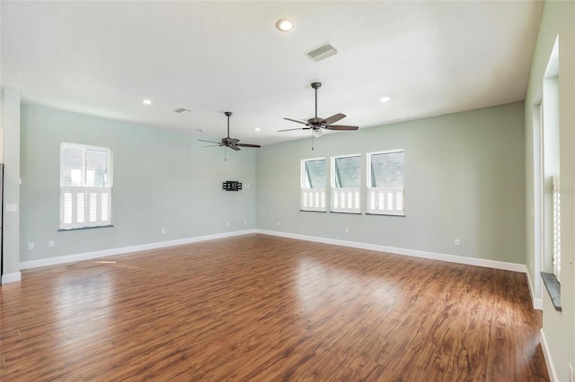 unfurnished room with dark wood-type flooring, plenty of natural light, and ceiling fan