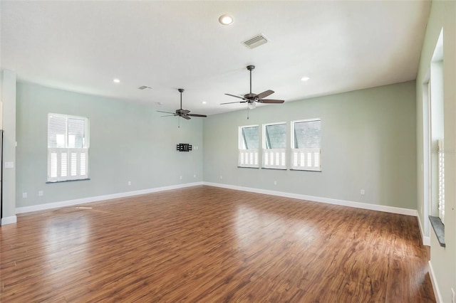 unfurnished living room with wood finished floors, a wealth of natural light, recessed lighting, and visible vents