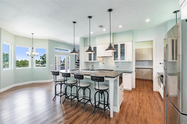 kitchen featuring dark countertops, backsplash, wood finished floors, and appliances with stainless steel finishes