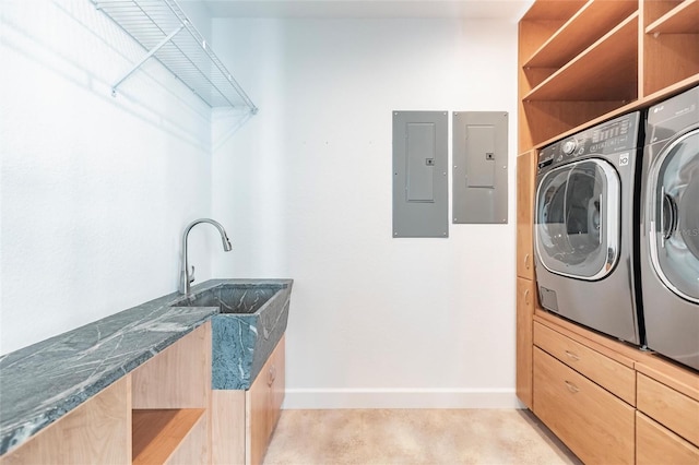 laundry area featuring electric panel, washing machine and clothes dryer, sink, and light colored carpet