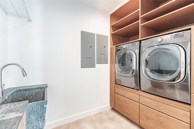 clothes washing area featuring electric panel, baseboards, washing machine and dryer, and laundry area