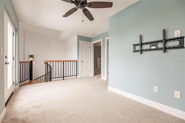 carpeted empty room featuring baseboards and ceiling fan
