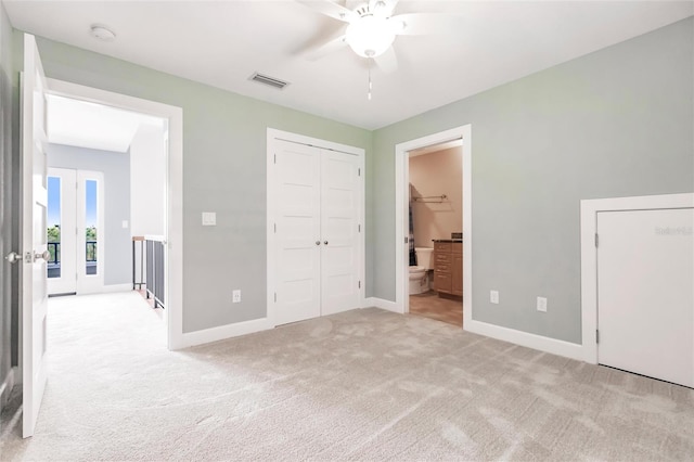 unfurnished bedroom featuring a ceiling fan, baseboards, ensuite bath, light colored carpet, and visible vents