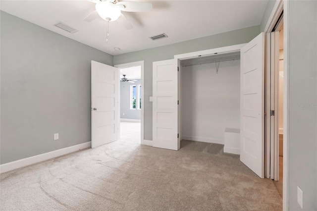 unfurnished bedroom with a closet, light colored carpet, and ceiling fan