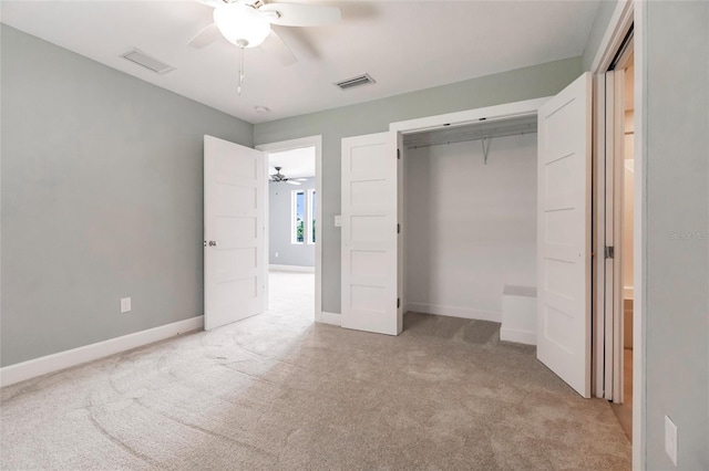 unfurnished bedroom with a closet, carpet flooring, visible vents, baseboards, and a ceiling fan